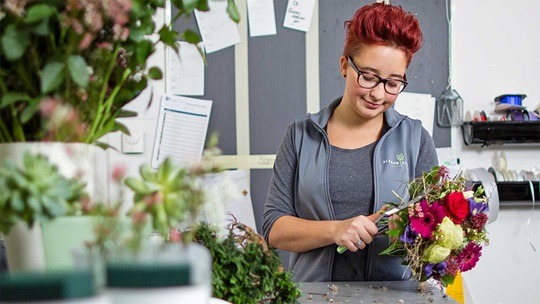 Eine Floristin bindet einen Blumenstrauss