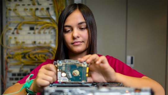 Eine Informatikerin hält ein Netzteil in der Hand