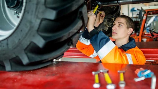 Ein Landmaschinenmechaniker zieht eine Schraube bei der Nockenwelle an