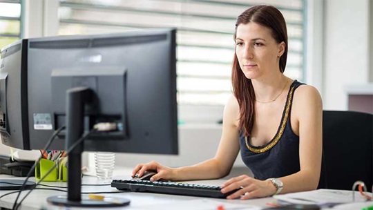 Eine Zeichnerin arbeitet am Computer in ihrem Büro