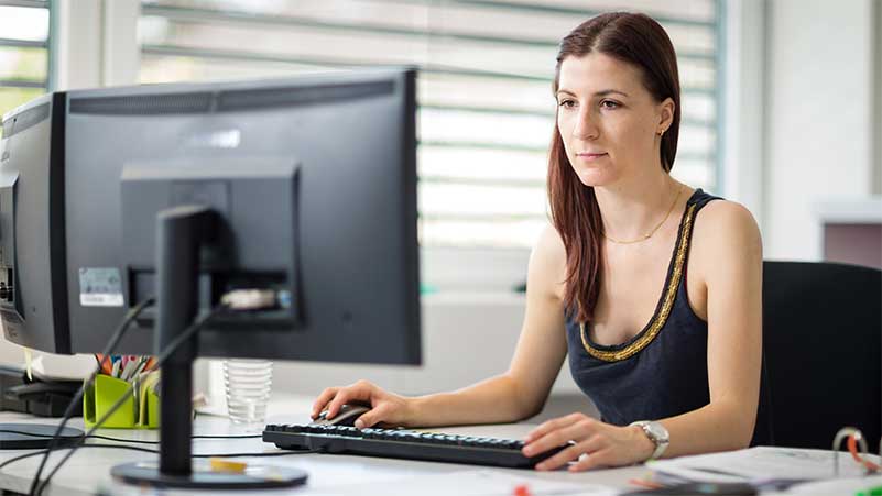 Eine Zeichnerin arbeitet am Computer in ihrem Büro
