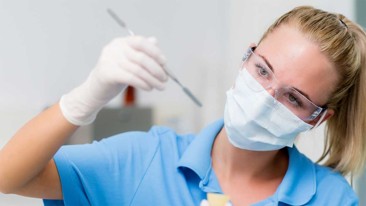 Eine Dentalassistentin bereitet eine Masse vor