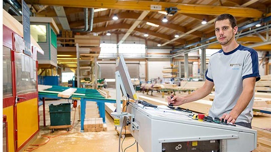 Ein Zimmermann steuert die Fräse in seiner Werkstatt