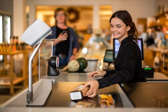 Eine Detailhandeslfachfrau an der Kasse