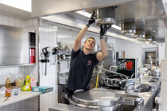 Ein Fachmann Betriebsunterhalt überprüft den Dampfabzug in einer Industrieküche
