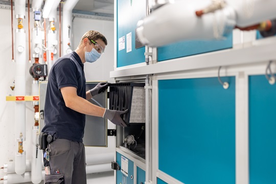 Ein Fachmann Betriebsunterhalt wechselt den Filter