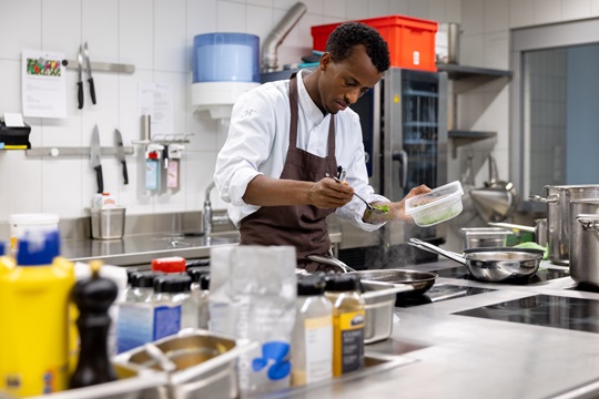 Ein Koch schmeckt das Essen ab