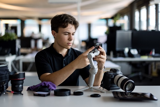 Ein Mediamatiker mit Gimbal und Moblie im Büro