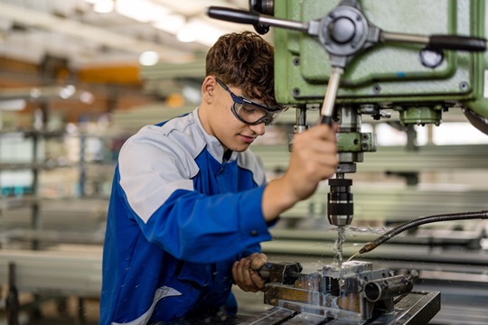 Ein Metallbauer bohrt ein Metallstück