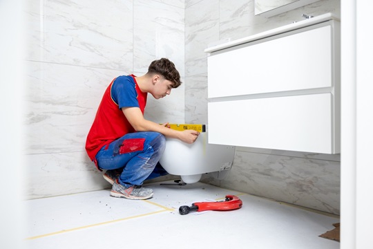 Ein Sanitärinstallateur montiert eine Toilettenschüssel