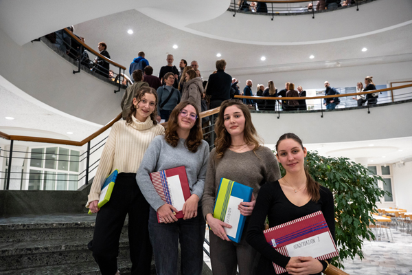 Vier Lernende stehen auf der Treppe. Sie halten ein Geschenk in der Hand, welches sie für ihre Projektarbeit erhalten haben.