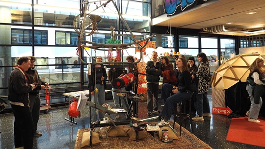 Besucherinnen und Besucher betrachten ein Ausstellungsobjekt.